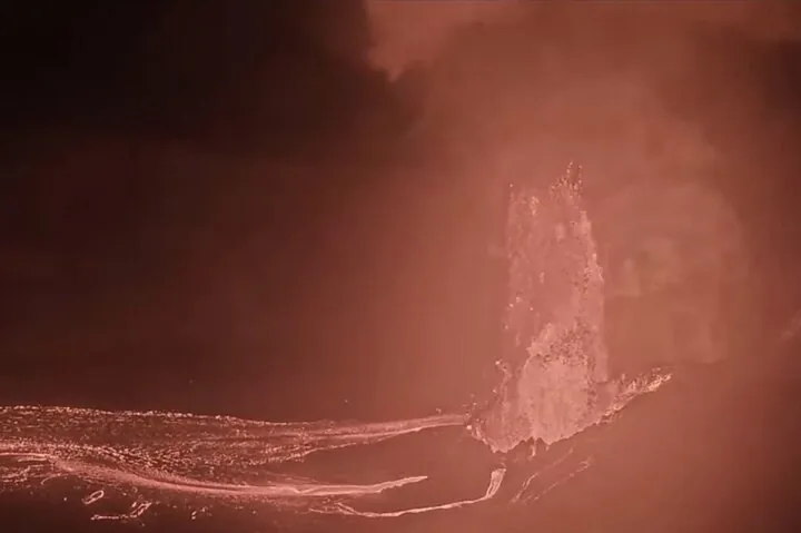 Nahaufnahme einer im Dunkeln ausbrechenden Lavafontäne.