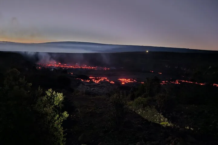 Night view of glowing lava flows in a volcanic crater.